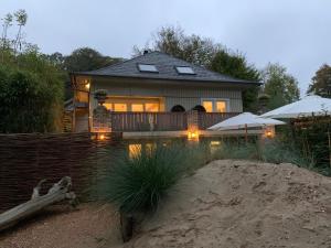 una casa con piscina frente a ella en Loft aan Zee, Penthouse B&B aan de Schoorlse duinen, en Schoorl