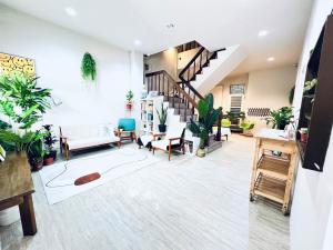 a living room with potted plants and a staircase at 微趣 WeChill in Tainan