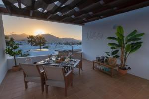 een eetkamer met een tafel en uitzicht op de oceaan bij Villalia Nayra in Playa Blanca