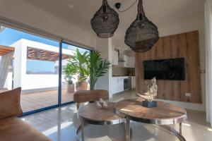 een woonkamer met een bank en een tafel bij Villa Nayra by Villalia in Playa Blanca