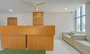 sala de estar con muebles de madera y sofá en Treebo Trend Green Land Kushalnagar en Kushālnagar