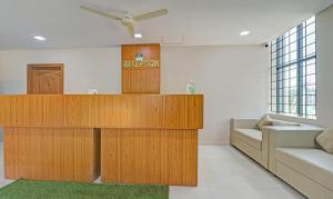 a living room with wooden furniture and a couch at Treebo Trend Green Land Kushalnagar in Kushālnagar