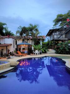 a swimming pool in front of a house at Villa Juana Hotel in Pereira