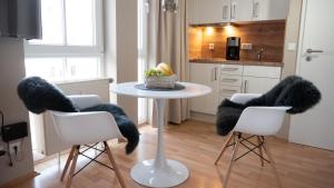 a kitchen with a table and two chairs with fur at Sehnsucht Rügen Ferienappartements in Ostseebad Sellin