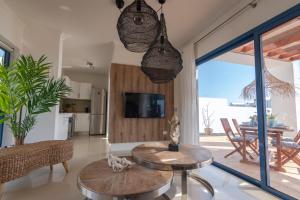 un salon avec deux tables et une télévision dans l'établissement Villalia Tahona, à Playa Blanca