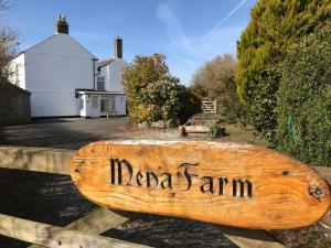 a wooden sign that says marina samm on a fence at The Old Farmhouse at Mena in Bodmin