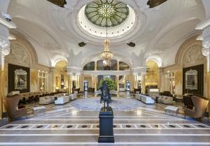 a large lobby with a statue in the center of a building at Hôtel de Paris Monte-Carlo in Monte Carlo