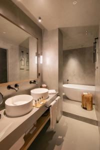 a bathroom with two sinks and a bath tub at Only YOU Hotel Málaga in Málaga