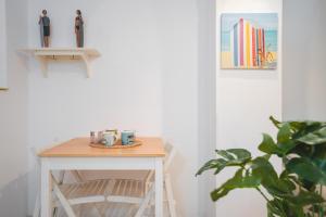 una mesa con tazas junto a una planta en Apartamentos LÓRIEN Zarautz, en Zarautz