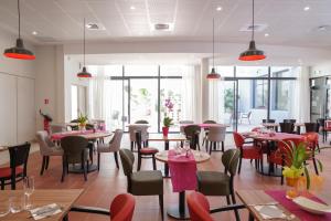 a restaurant with tables and chairs and windows at Résidence d'Avignon in Avignon