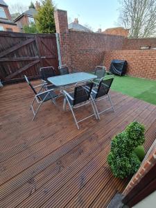 a patio with a table and chairs on a deck at Cooperage House All Ensuite Property - Sleeps 18 in Sheffield