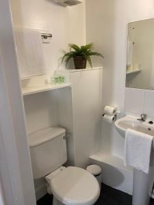 a white bathroom with a toilet and a sink at 8 Bed 9 Bath Ensuite House with Hot Tub and Free Parking in Sheffield