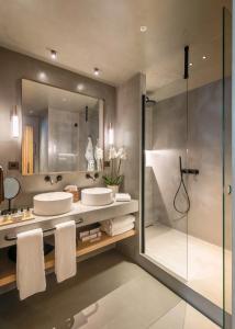 a bathroom with two sinks and a shower at Only YOU Hotel Málaga in Málaga