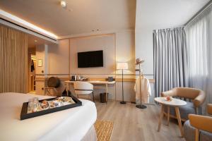 a hotel room with a bed and a living room at Only YOU Hotel Málaga in Málaga