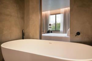 a bath tub in a room with a bedroom at Only YOU Hotel Málaga in Málaga
