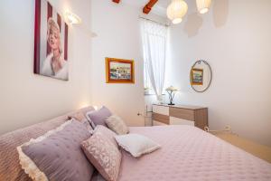 a bedroom with a bed with pillows on it at Apartments Villa Ida in Zadar