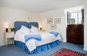 a blue and white bedroom with a large bed at The Old Manor House in Halford