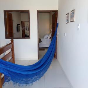 a hammock in a room with a bedroom at Flat Galemares in Maragogi
