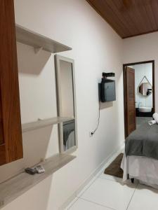 a bedroom with a mirror and a tv on the wall at Flat Galemares in Maragogi