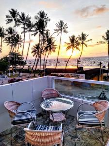 a patio with chairs and a table and the beach at Flat Galemares in Maragogi