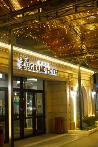 a grand hotel with a sign on the front of it at ATB Grand Hotel in Atyraū