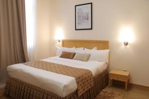 1 dormitorio con 1 cama grande en una habitación de hotel en ATB Grand Hotel en Atyraū
