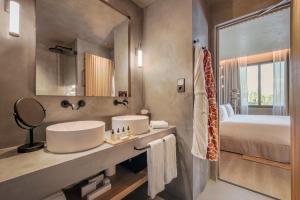 a bathroom with a sink and a bed and a mirror at Only YOU Hotel Málaga in Málaga