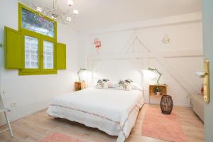 sypialnia z białym łóżkiem i zielonymi szafkami w obiekcie Apartamentos LÓRIEN Zarautz w mieście Zarautz