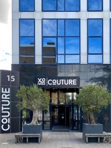 ein Gebäude mit zwei Bäumen davor in der Unterkunft XO Hotels Couture in Amsterdam
