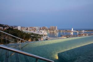 a balcony with a view of the water and a city at Only YOU Hotel Málaga in Málaga