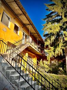 a yellow building with stairs next to a tree at Green Apartman in Eger