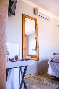 a mirror on a wall in a room with a table at Thavhani Guest House in Thohoyandou