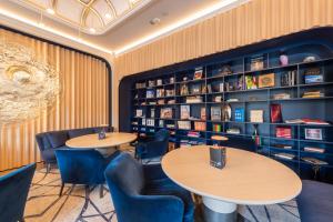 a room with a table, chairs, and bookshelf at StandArt Hotel Moscow in Moscow