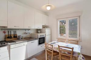 a kitchen with white cabinets and a table and chairs at Santa Lucia in Imperia