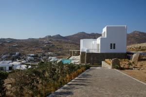 a path leading to a white building on a hill at Absolute Paradise Villa Tourlos in Mikonos