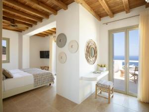a bedroom with a bed and a view of the ocean at Absolute Paradise Villa Tourlos in Mikonos +86 photos
