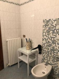 een badkamer met een wastafel en een tafel naast een toilet bij Camera San Jacopo in Altopascio
