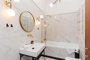 a bathroom with a sink and a tub and a mirror at LUX Golden Apartment Praga Kępna by Renters Prestige in Warsaw