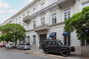 a green jeep parked in front of a building at LUX Golden Apartment Praga Kępna by Renters Prestige in Warsaw