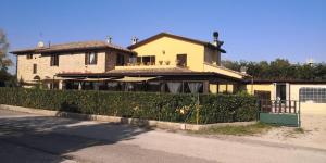 een geel huis met een hek ervoor bij Locanda della Braccesca in Ponte Pattoli