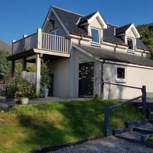 a house with a balcony on top of it at The View at Pier House Glencoe in Glencoe