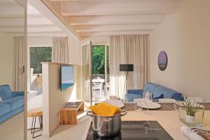 a living room with a blue couch and a table at Lamasu RioVerde - Lago di Garda in San Felice del Benaco