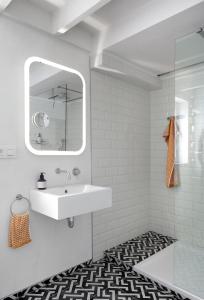 Baño blanco con lavabo y espejo en Loftsuite, en Gante