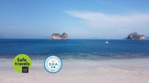 a sign on a beach with two large rocks in the water at Koh Ngai Kaimuk Thong Resort in Ko Ngai