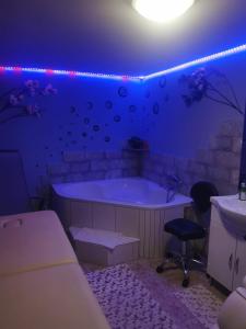 a purple room with a tub and a sink at Apartma AJJA in Šenčur