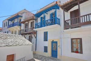 een groep gebouwen met blauwe deuren en balkons bij Skopelos house in Castle in Panormos Skopelos