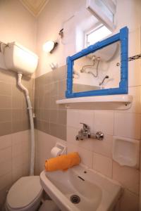 een badkamer met een wastafel, een toilet en een spiegel bij Skopelos house in Castle in Panormos Skopelos