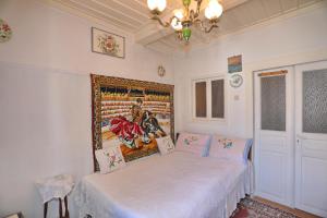 een slaapkamer met een bed en een schilderij aan de muur bij Skopelos house in Castle in Panormos Skopelos