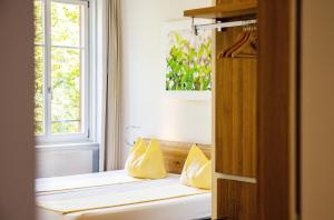a window seat in a room with yellow pillows at ODELYA - Stadthotel im Park in Basel