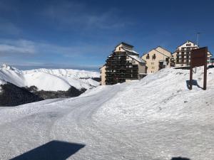 uma montanha coberta de neve com edifícios ao fundo em plein sud em Saint-Aventin